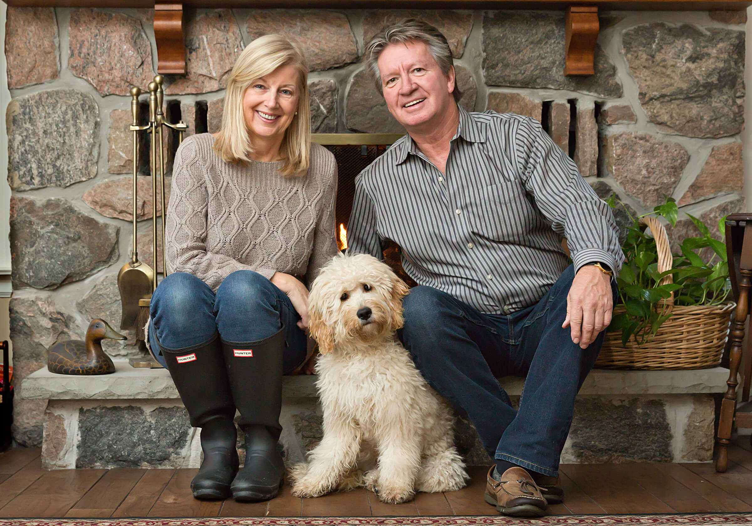 couple photographed with doodle dog in their home
